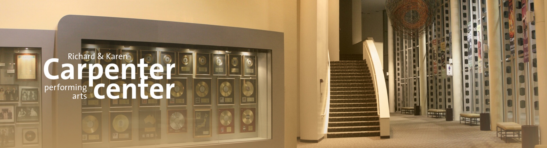 The interior of the Carpenter Center lobby with a case of gold records by the Carpenters visible along one wall.