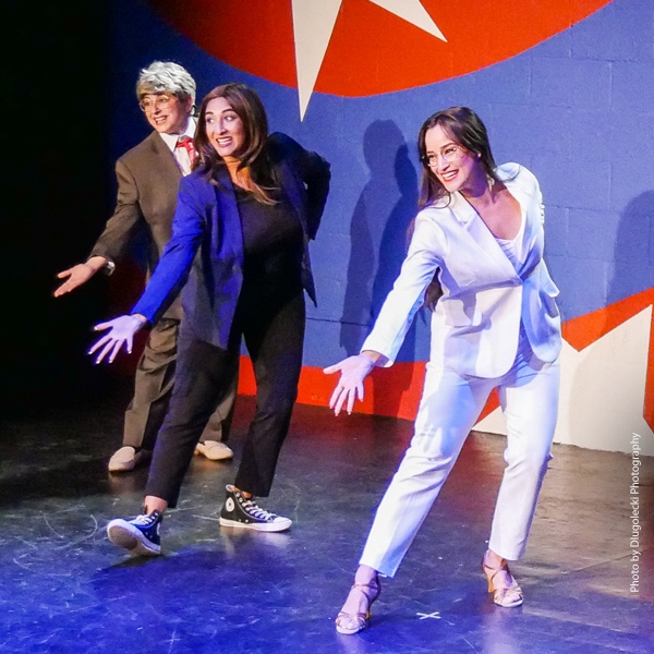Three members of the comedy troupe in costume performing on stage