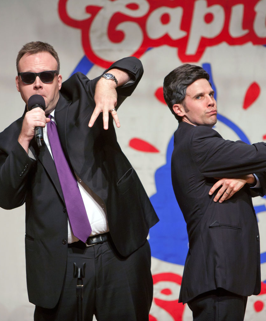Two members of Capitol Steps on stage in mid-performance.