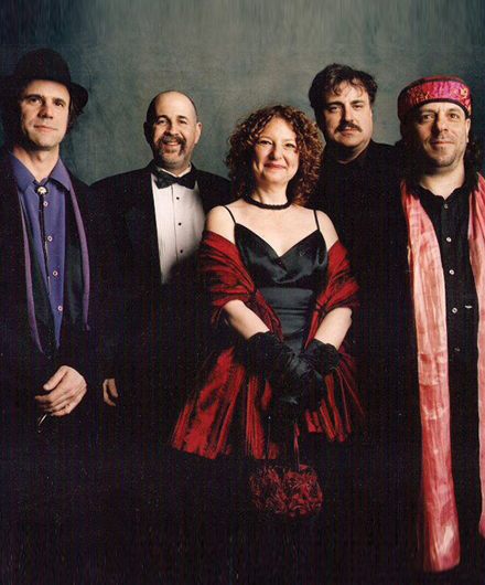 Members of The Klezmatics posing together and smiling.