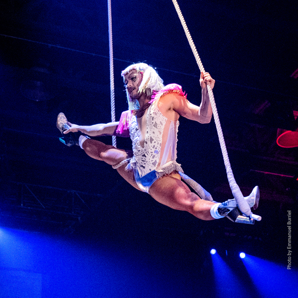 A member of FLIP Fabrique doing the splits while suspended in mid-air.