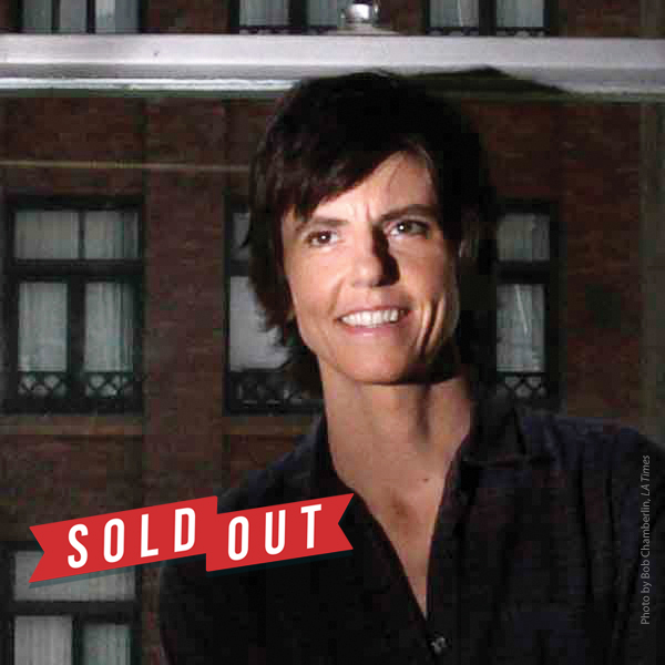 Tig Notaro standing by a window with the words SOLD OUT displayed in the corner.