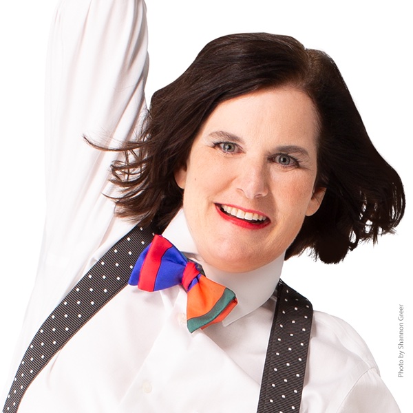 Paula Poundstone in a white shirt, colorful bow tie and suspenders.