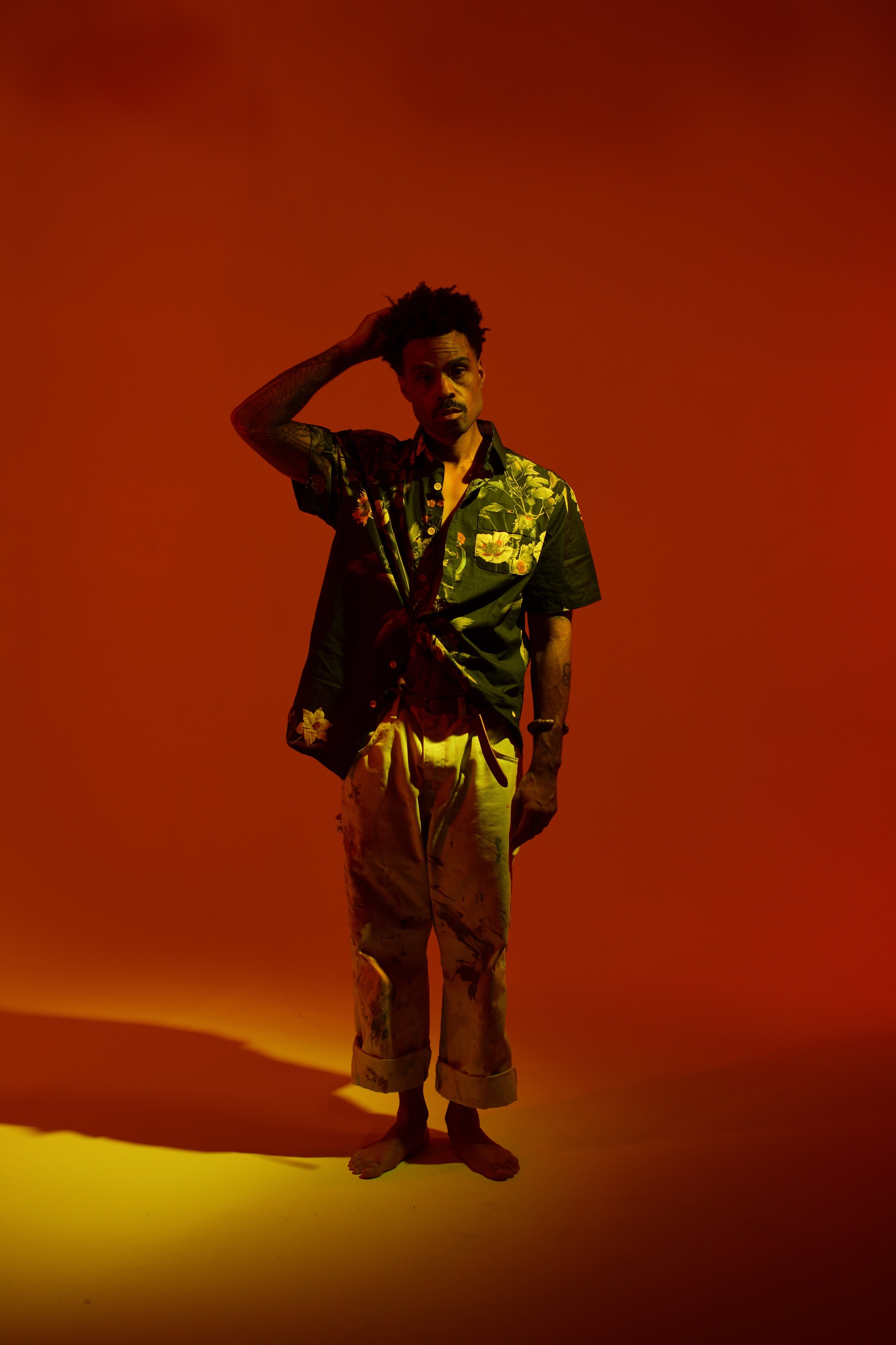 Bilal with one hand on his head in a floral shirt