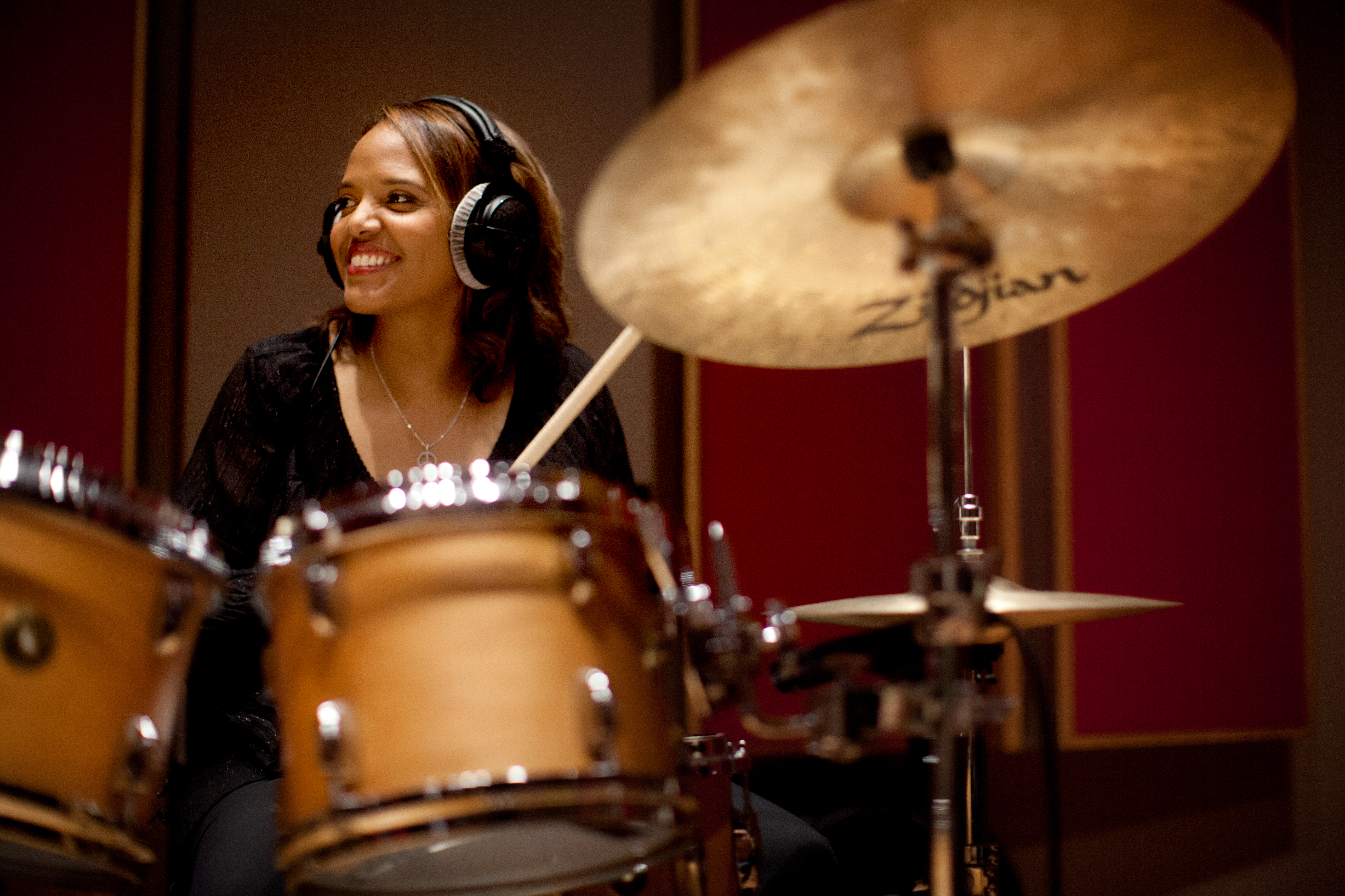Terri Lyne Carrington seated at the drums and smiling