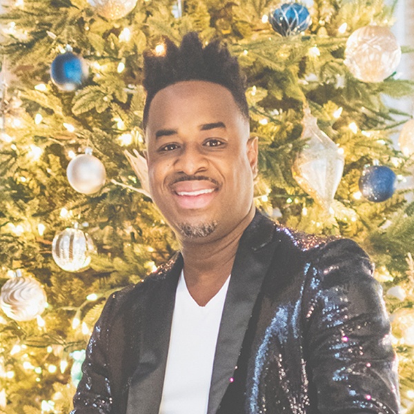 4-damien-sneed_0.jpg Damien Sneed in front of a brightly lit Christmas Tree