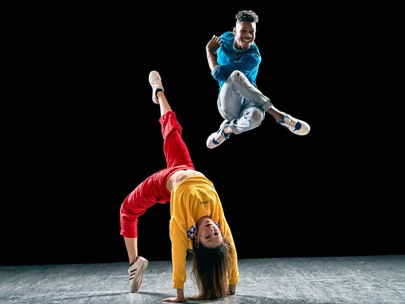 Two dancers from Versa-Style Dance Company on a stage, one j