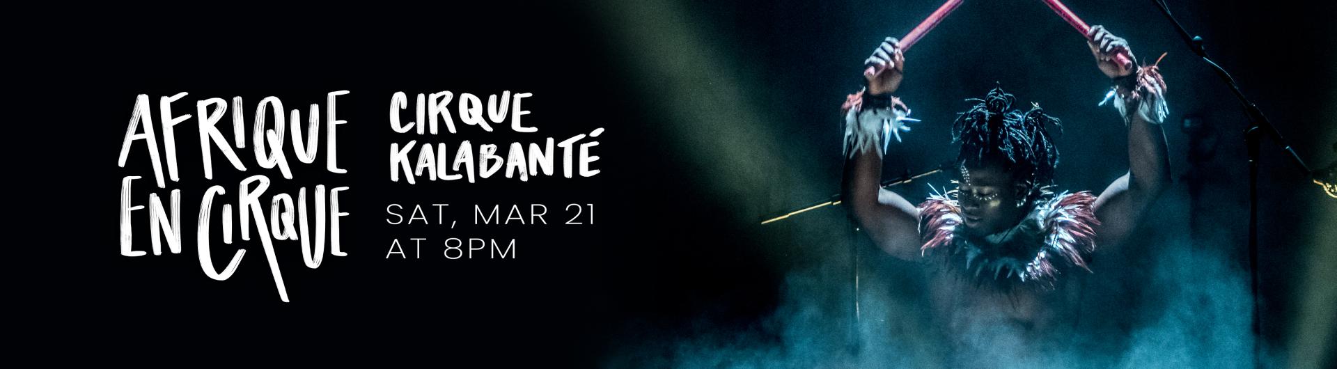 A member of Cirque Kalabanté on the drums with dramatic lighting.