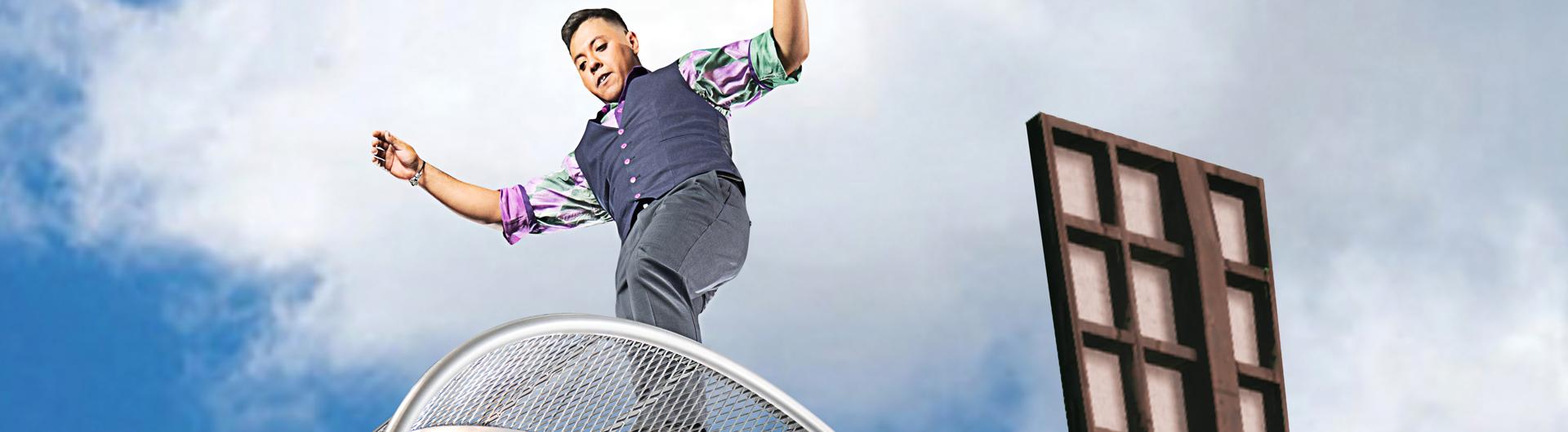A member of Cirque Mechanics balancing atop a windmill.