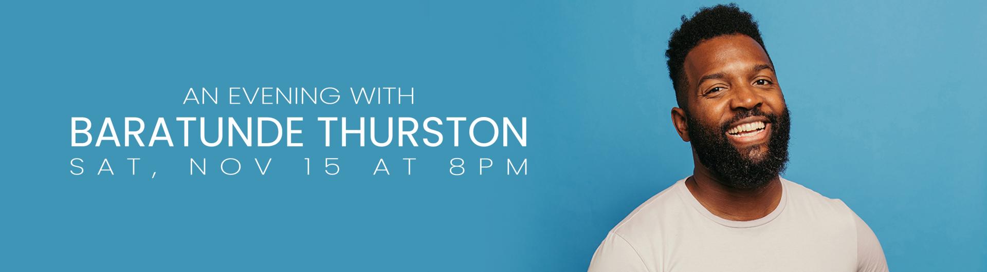 Baratunde Thurston smiling in a white shirt against a light blue background