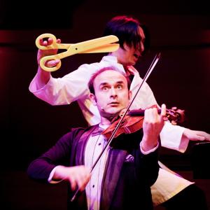 12-igudesman-joo-v262.jpg Igudesman on the violin as Joo stands over him with an overs