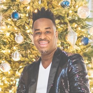 4-damien-sneed_0.jpg Damien Sneed in front of a brightly lit Christmas Tree