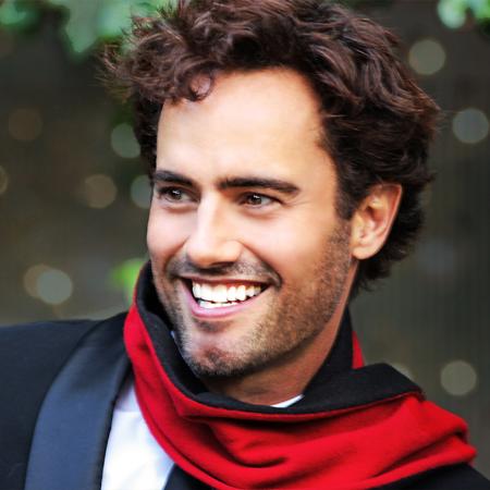 David Burnham smiling with a red scarf around his neck