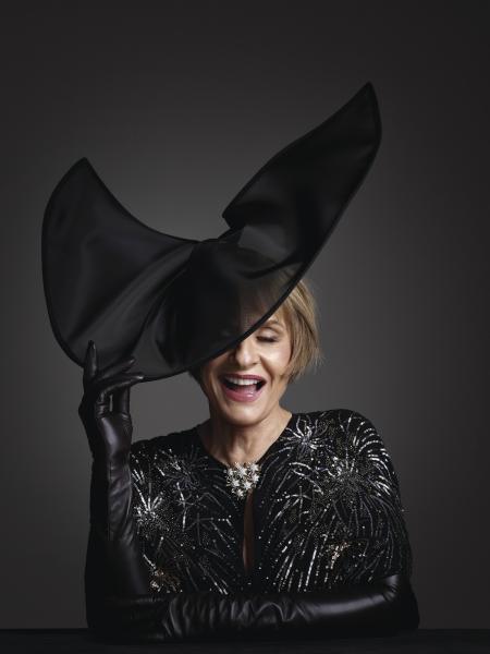 Patti LuPone in a black outfit and hat.